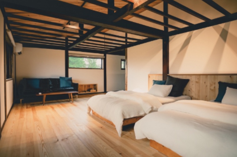 A bedroom in the kominka — timber beams and made-up beds